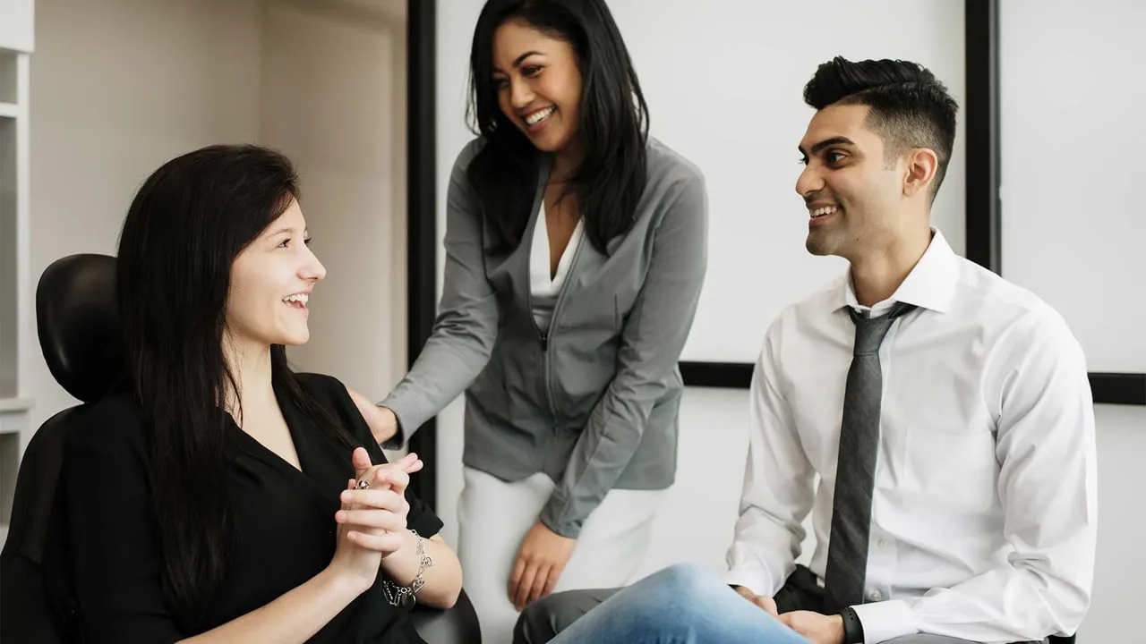 Photo of two dentists talking with a patient