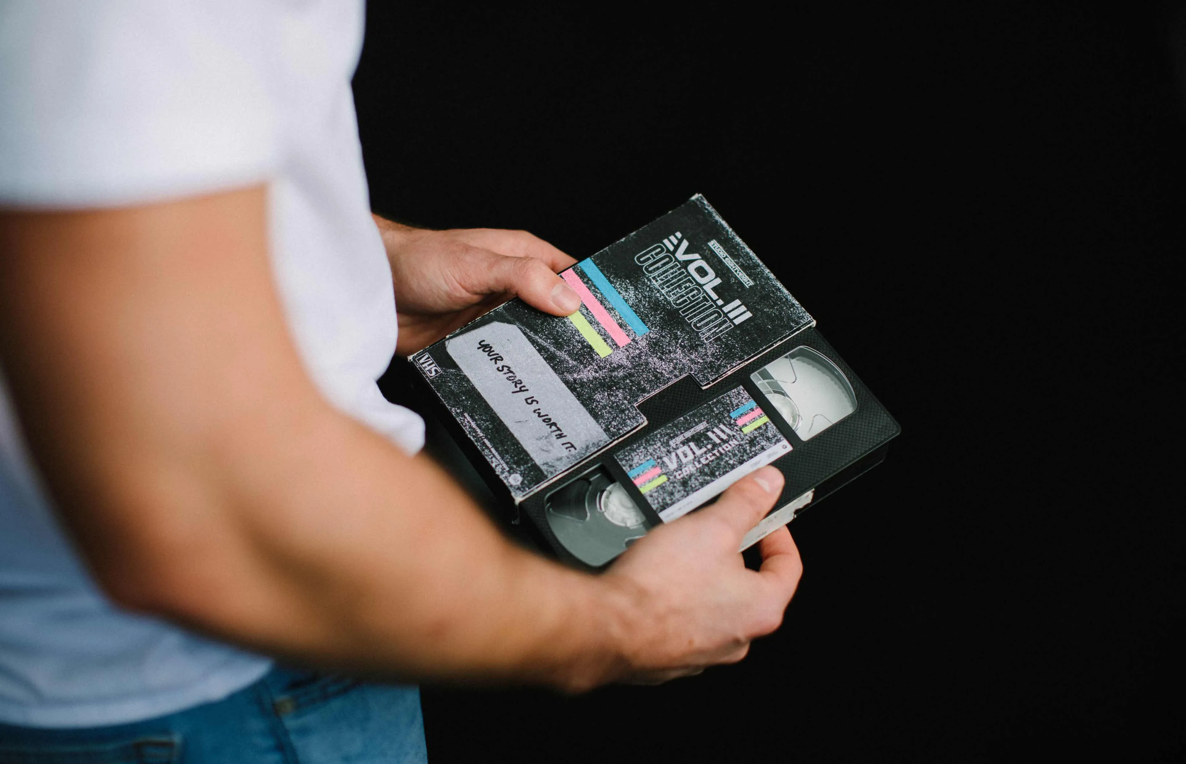 Photo of a man holding a S8E8 Volume 3 Collection VHS tape