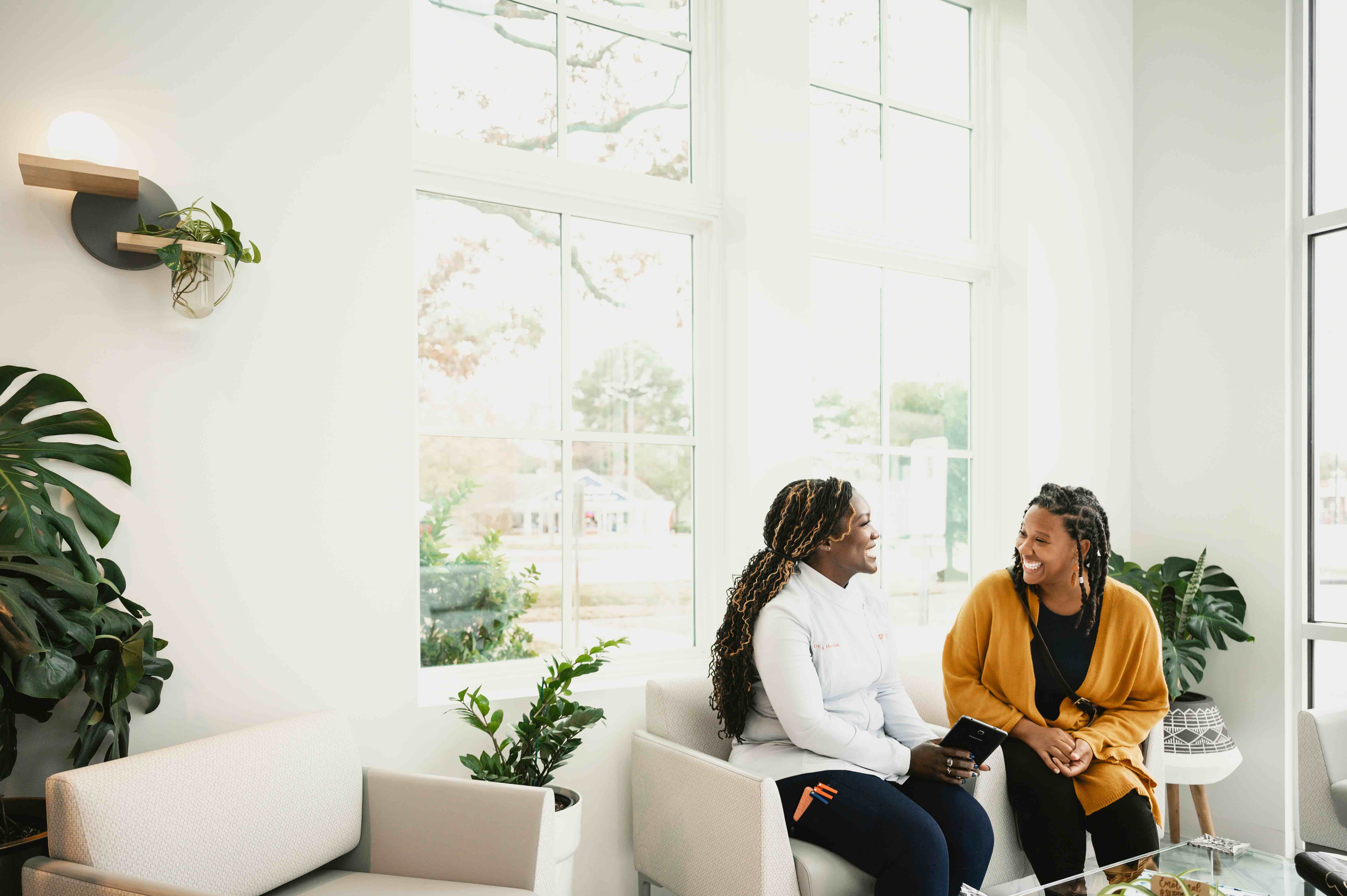 A dentist and patient sit together on a sofa