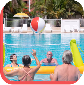 A lively group of individuals enjoying a game of volleyball in a swimming pool, showcasing teamwork and fun.