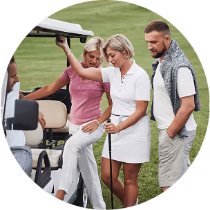 Three individuals stand beside a golf cart, engaged in conversation on a sunny day at a golf course.