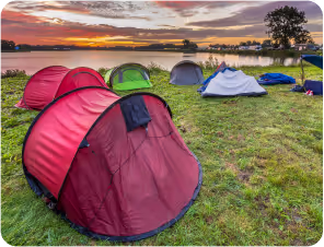 A serene sunset casts a warm glow over a cluster of tents