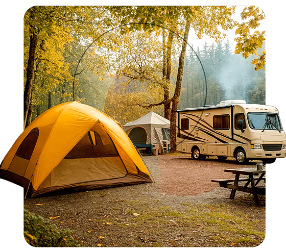 Yellow tent and RV parked at a wooded campsite with a picnic table in the foreground