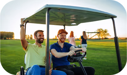 Two men seated in a golf cart on a golf course