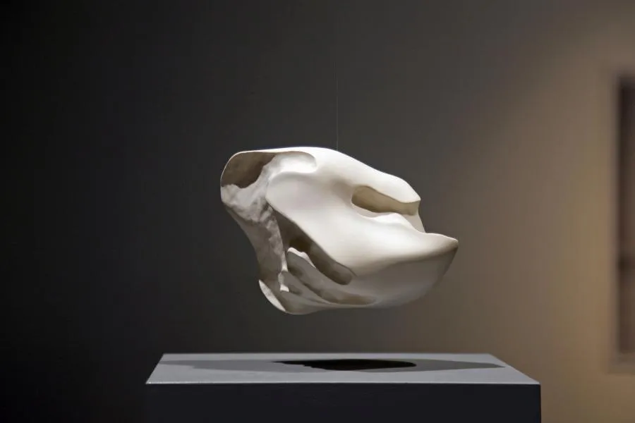 Sculptural artwork. A white ceramic blob that visualize the negative space between an handshake