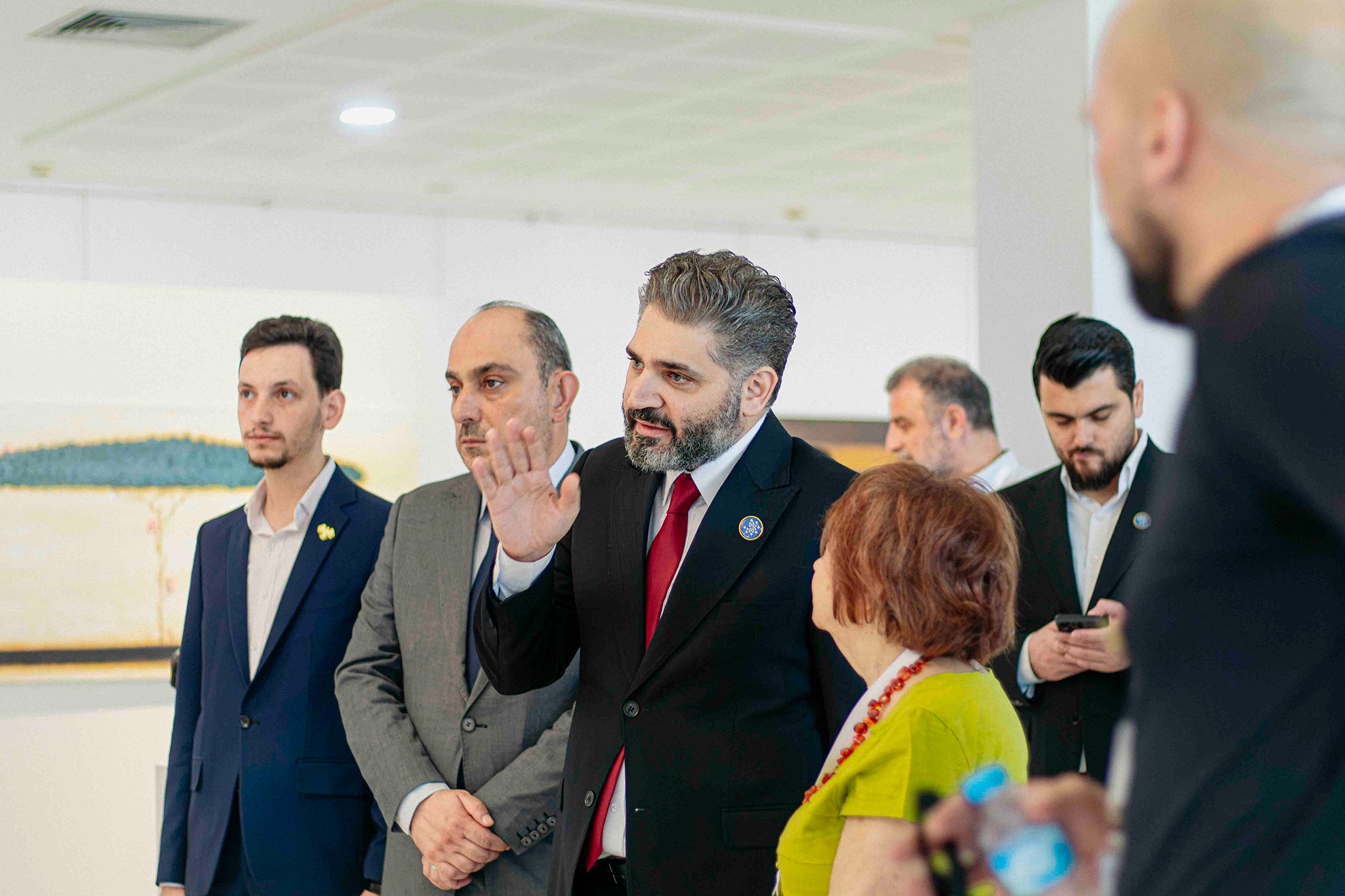 Visitors in conversation among the artworks at Art Leaves Its Mark, 2026. Photograph by Jawad Allazkani.