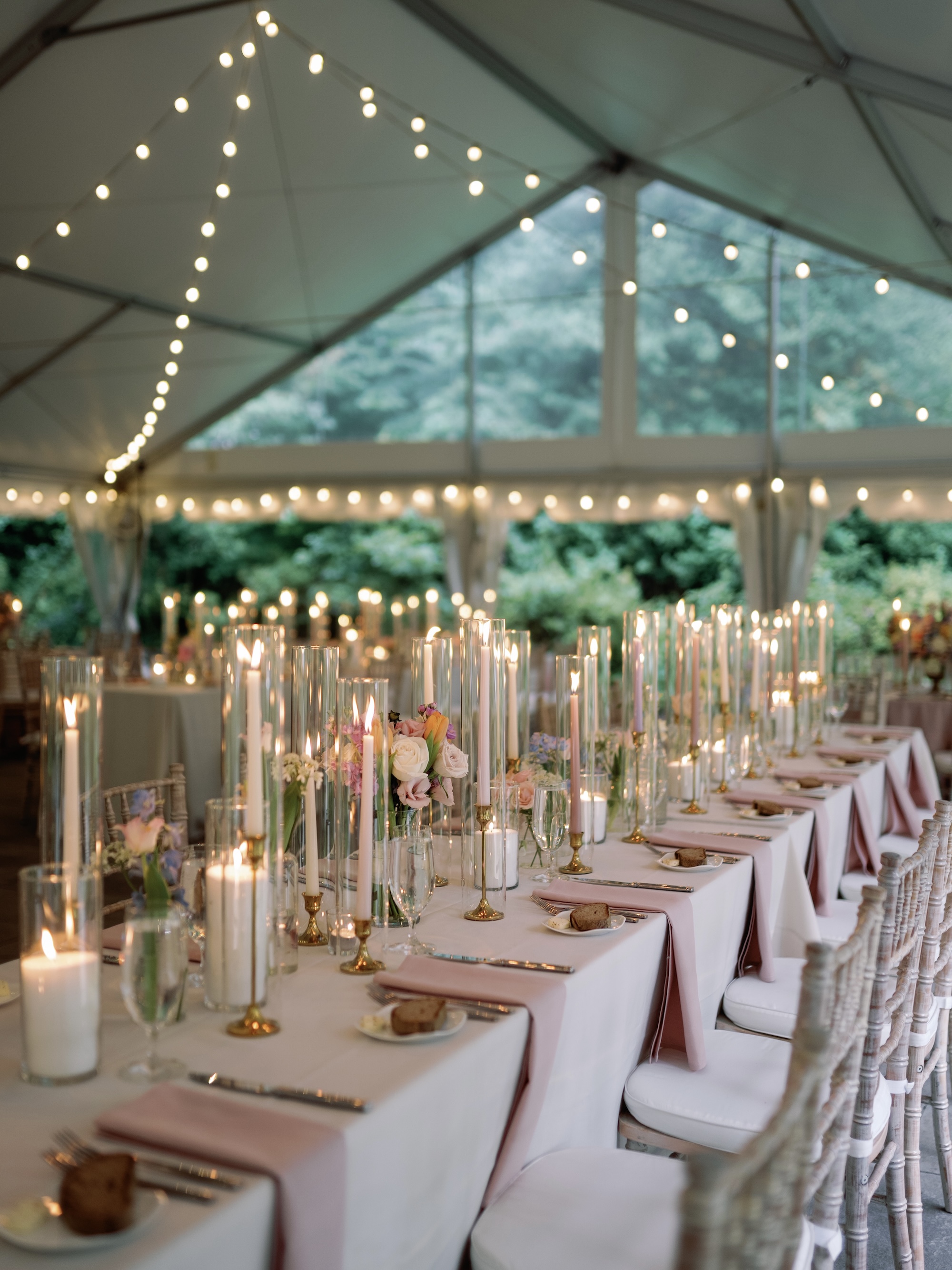 Beautiful long table with candles set under the Portico tent with the gardens of the Arboretum surrounding.