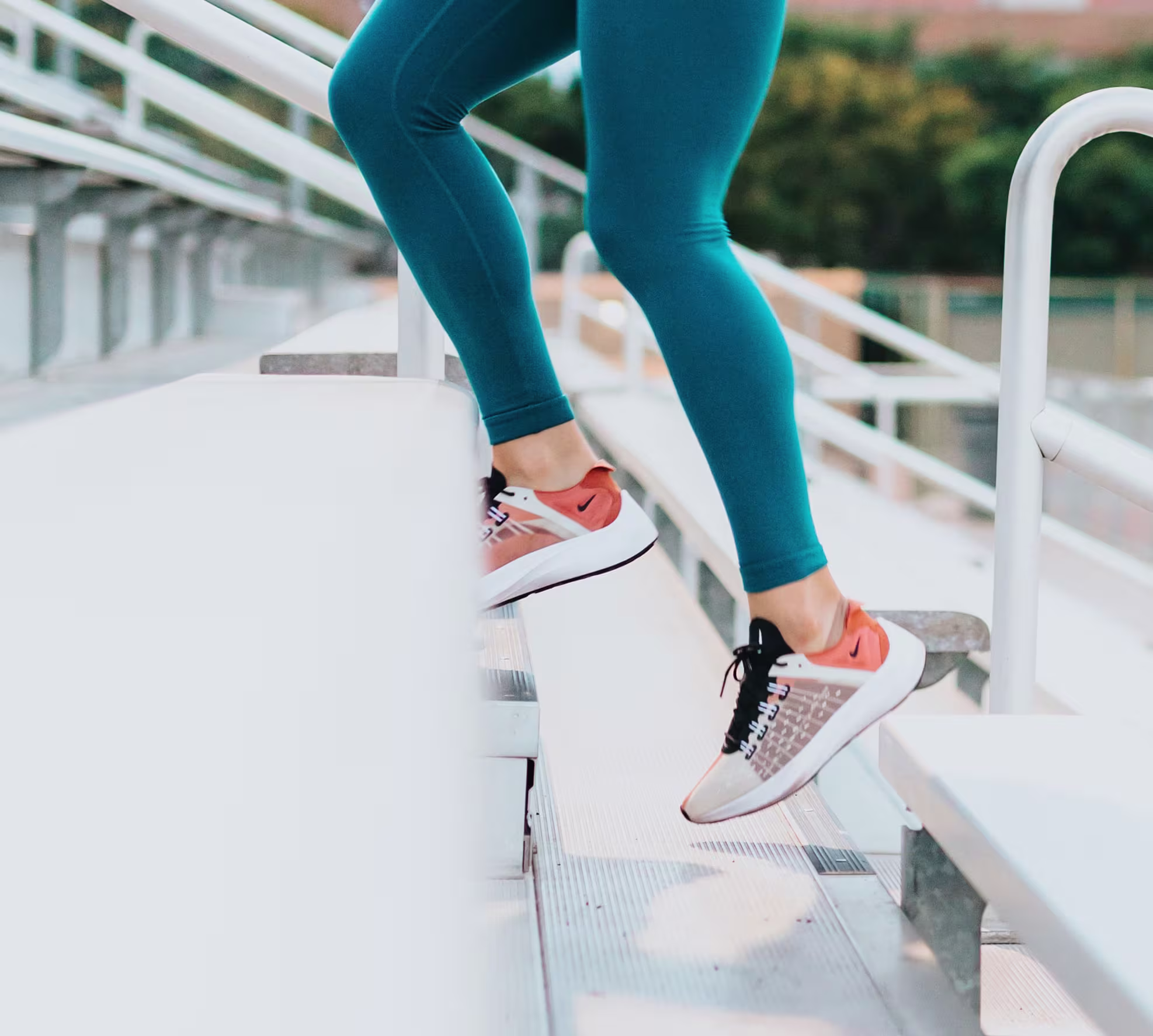 A person running up steps in exercise shoes, representing a fitness-focused theme related to Dr. Tracy Thompson.