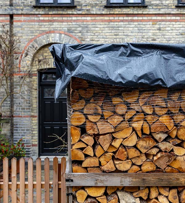 A newly delivered pile of firewood, still wrapped in plastic, in front of a house in Copenhagen, Denmark.