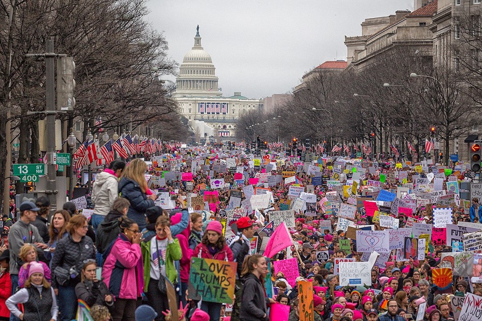 2017 women's march in Washington D.C. a crowd of women holding signs and wearing pink pussy hats in front of the capital building