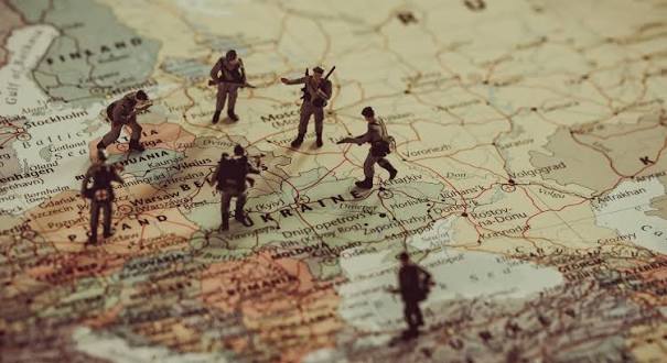 Miniature toy soldiers standing on a vintage map of Ukraine and Eastern Europe.