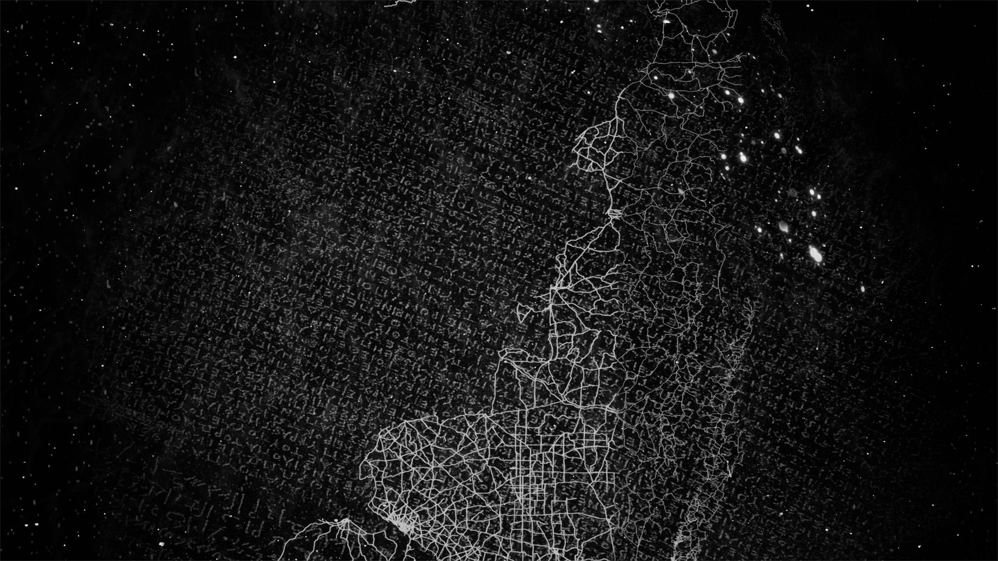 Black and white digital map with illuminated network of roads and bright clustered points of light on the right side.