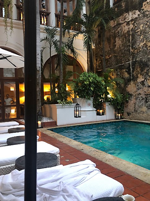 Cabana pool framed by palms and lantern light