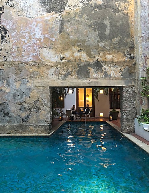 Indoor pool beside a rough stone wall