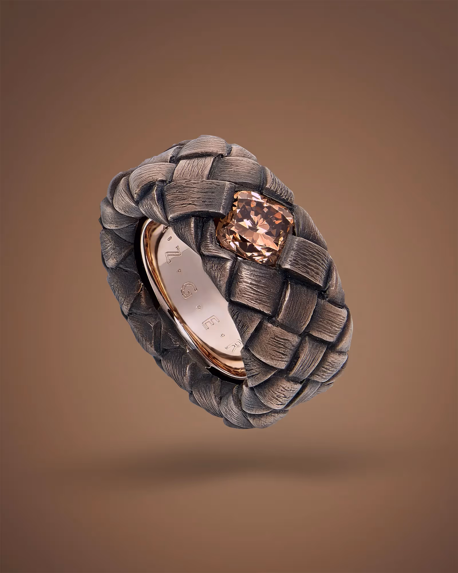 photographie de bague en or brossé avec une pierre précieuse brune, photographe de bijoux philippe hahn