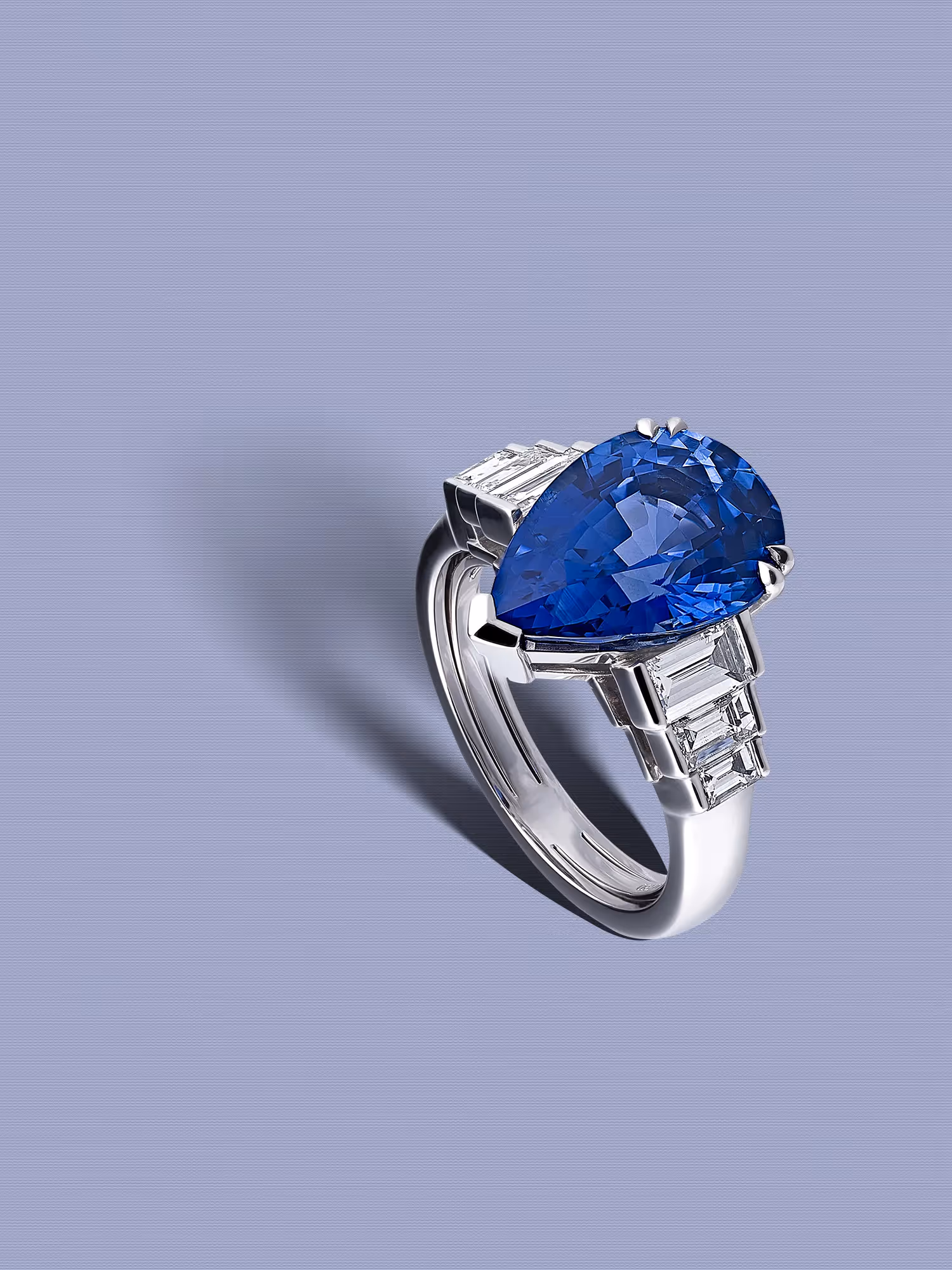photographie de bijoux haute joaillerie d'une bague en or blanc, poir saphir bleu et diamants baguette. Prise de vue en studio photo par philippe hahn