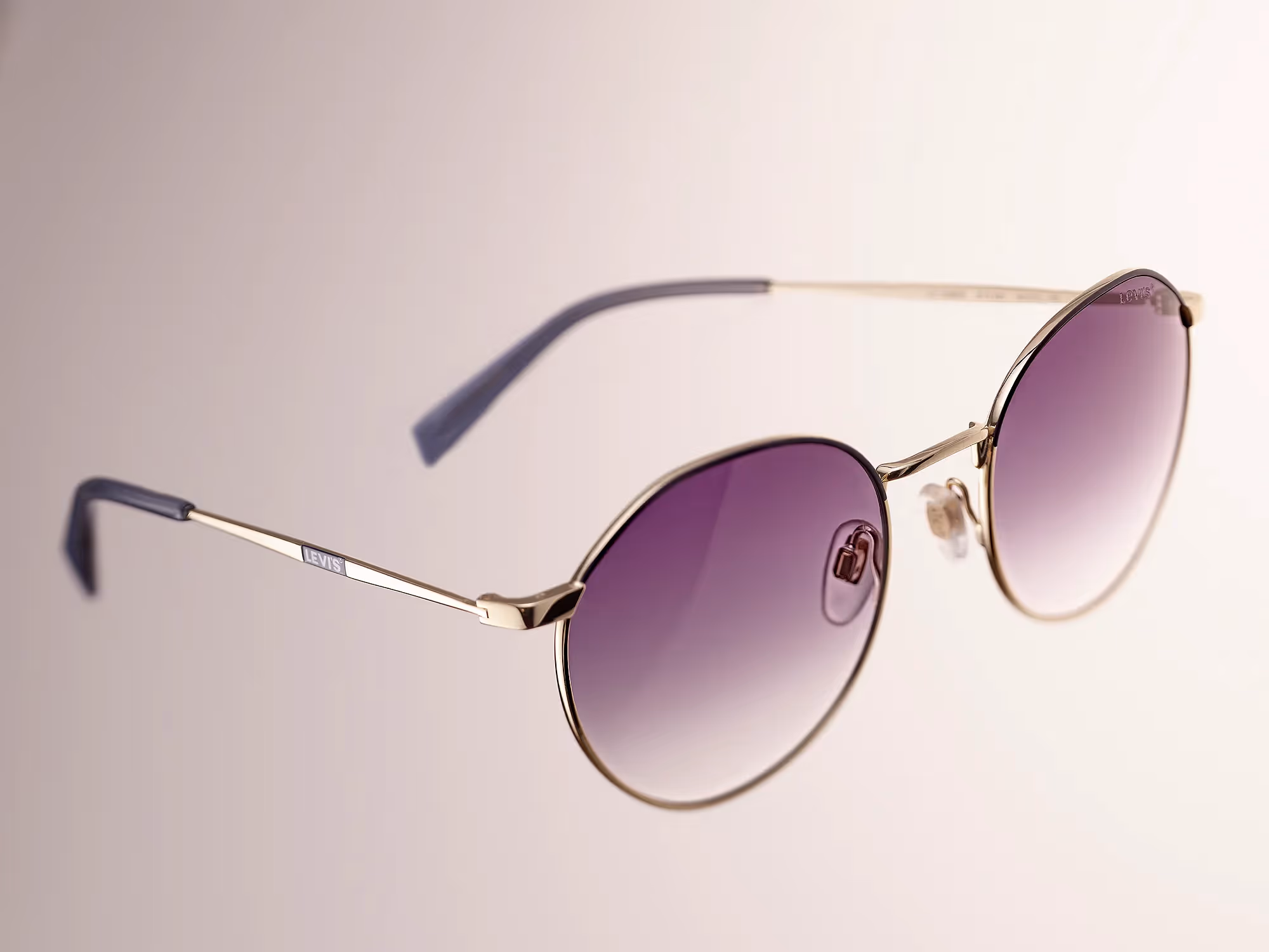 image packshot de lunettes de soleil de la marque levis, monture dorée et verres dégradés de couleur bleue