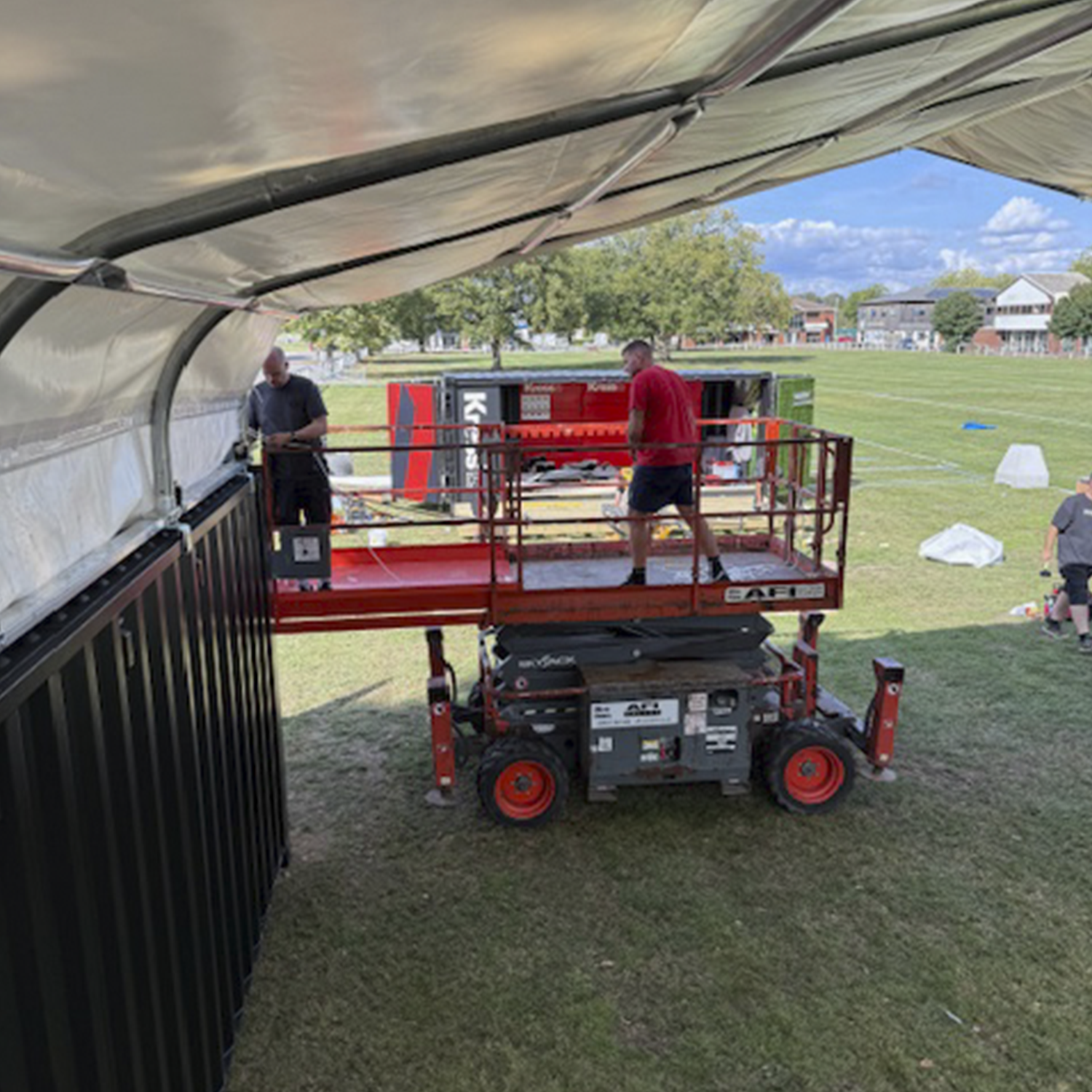 The Impact Design and Print team hard at work erecting the overhead roof structure on the Kress stand at Groundsfest.