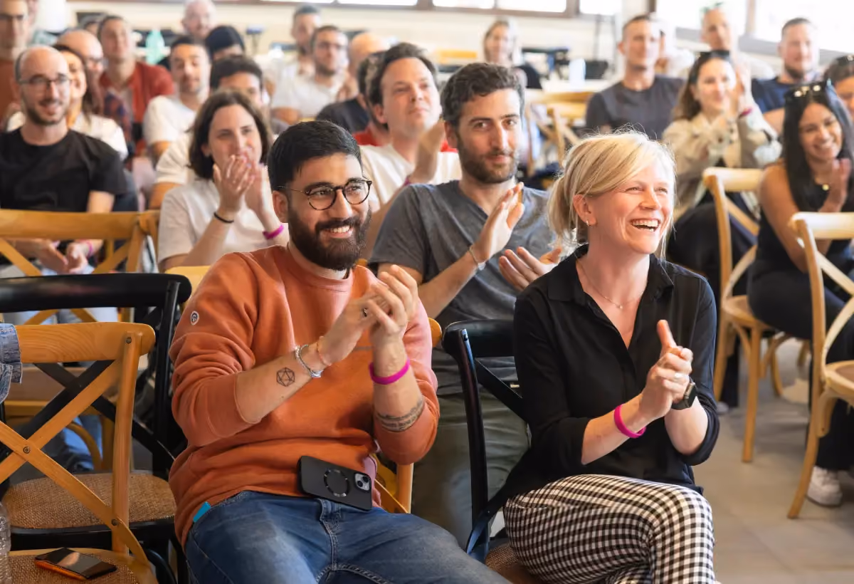 Gruppo di persone di un team che applaude durante un team building aziendale