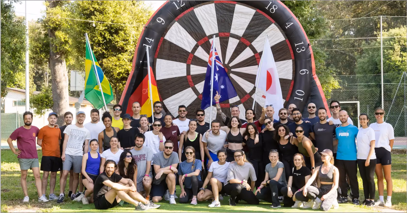 Foto di gruppo con bandiere dopo team building outdoor