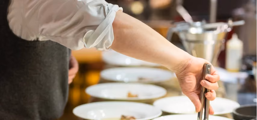 Uomo in un corso di cucina che impara ad impiattare