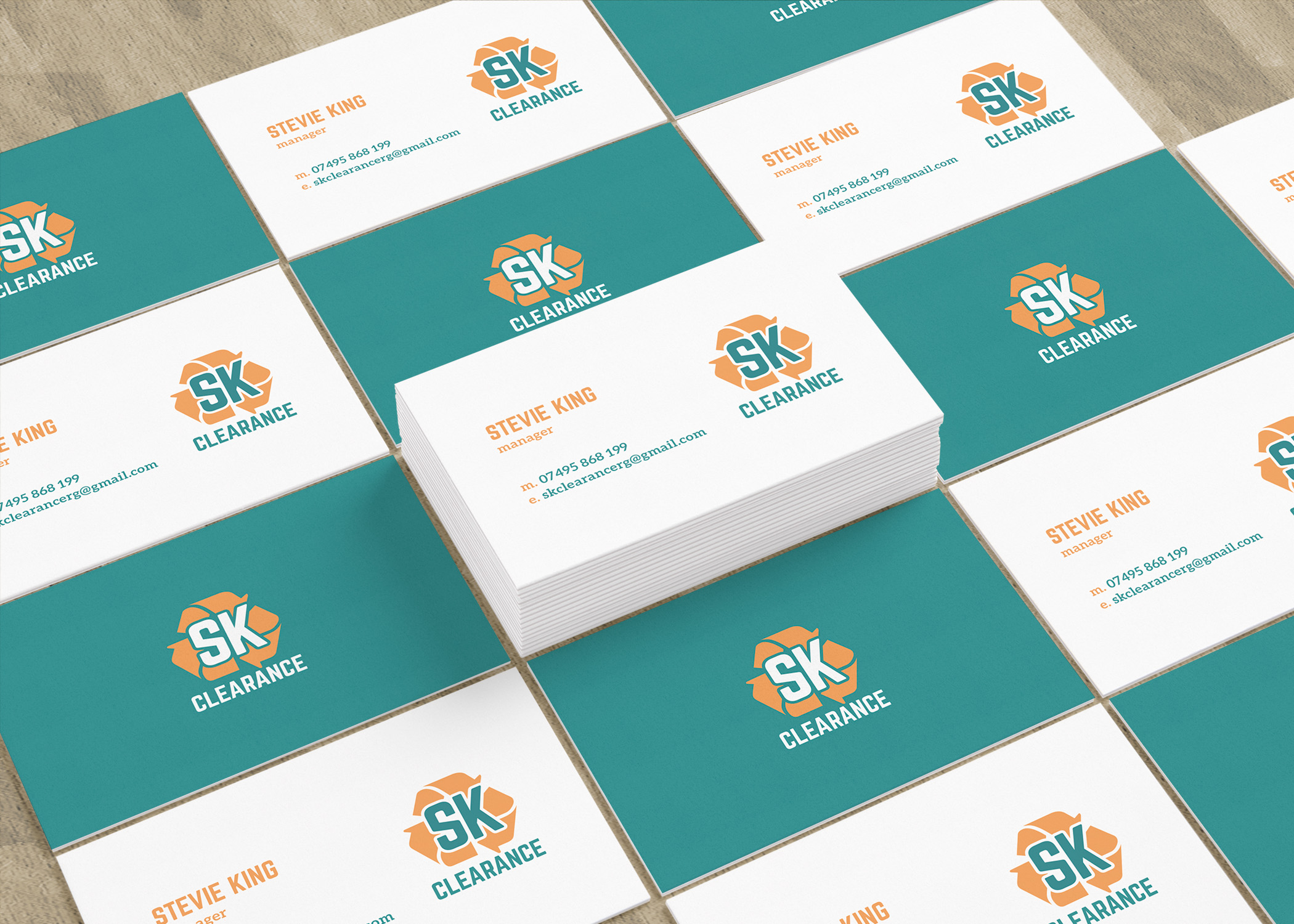 SK Clearance business cards in teal, white and orange, laid out in rows around a central stack