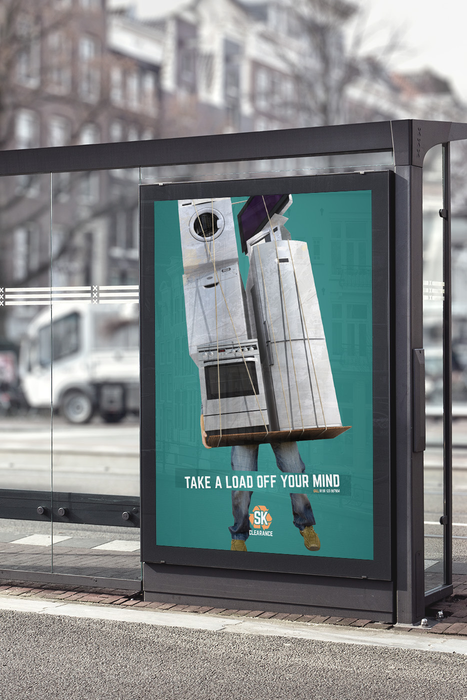 Mock-up of an SK Clearance poster in a bus shelter: a man carrying a fridge and a cooker, with the line 'Take a load off your mind'