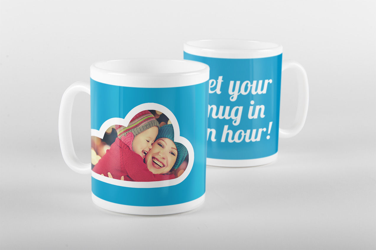 Two blue photo mugs, one with a cloud-shaped photo frame of two smiling children in woolly hats, the other reading 'Get your mug in an hour!'