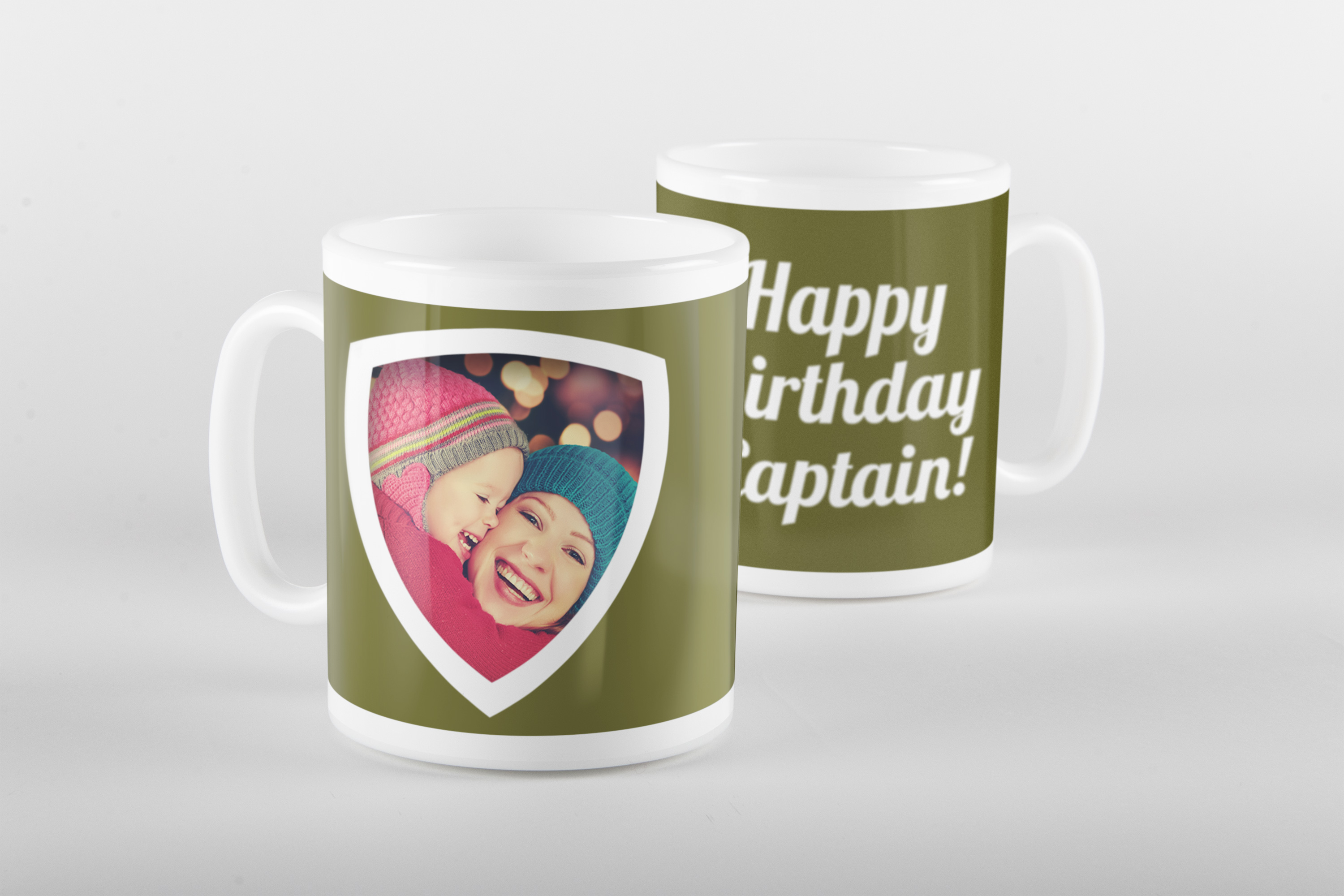 Two olive green photo mugs, one with a shield-shaped photo frame of two children, the other reading 'Happy Birthday Captain!'