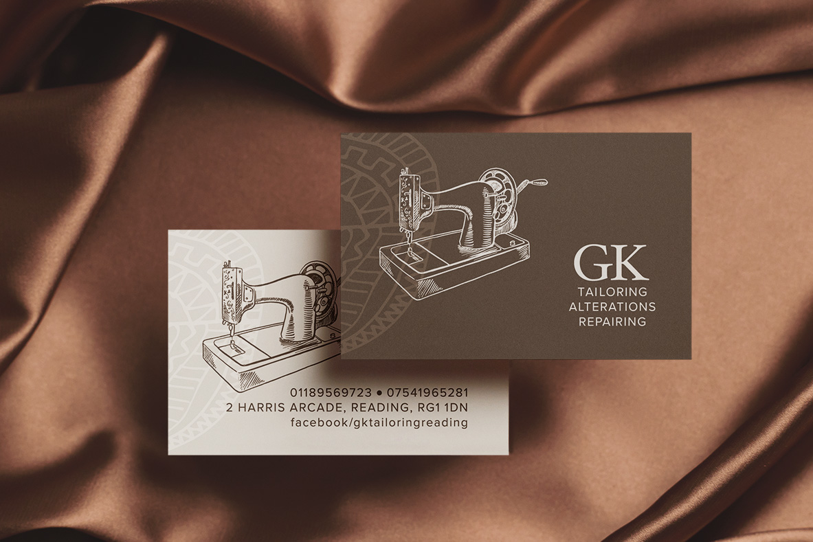 GK Tailoring and Alterations business cards with a vintage sewing machine illustration, on brown silk