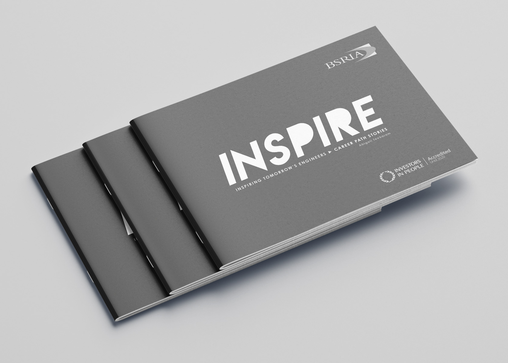 Stack of Inspire brochures with a grey cover and the white title 'INSPIRE'