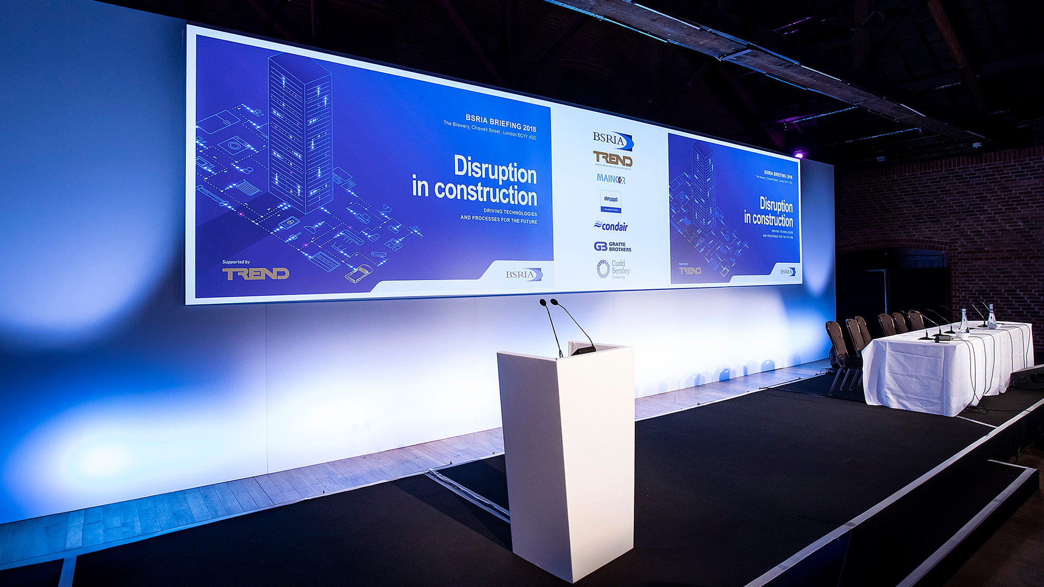 Conference stage for BSRIA's 'Disruption in construction' event, with a lectern in front of the blue branded backdrop