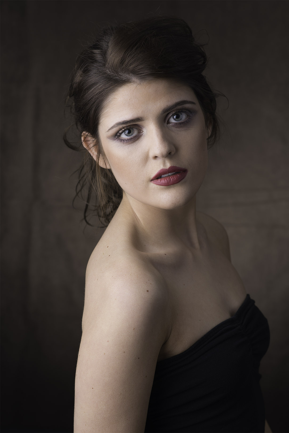 Original portrait of a dark-haired woman in a strapless black top, before retouching