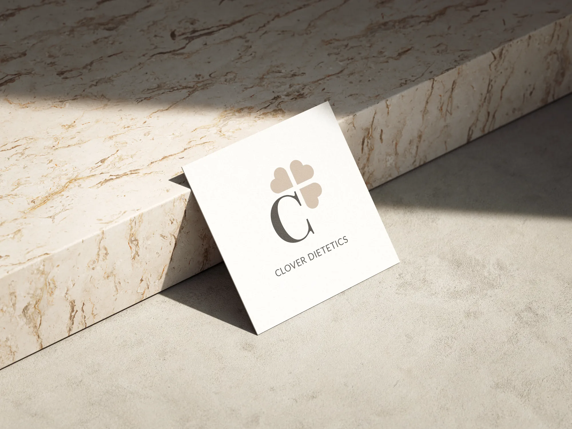 Clover Dietetics business card leaning on marble