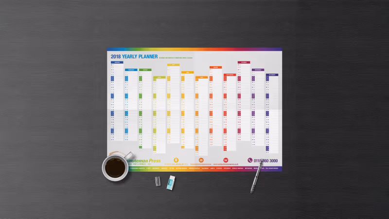 Colour-coded yearly wall planner on a desk