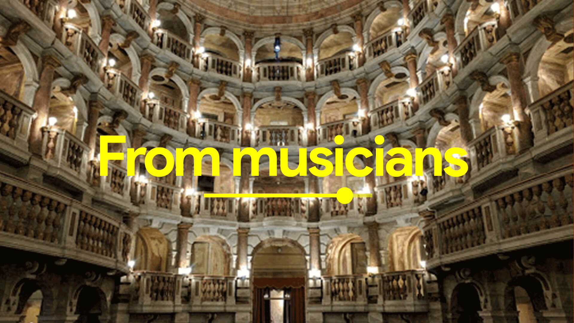 Interior of an ornate, multi-tiered stone theater with arched balconies and warm lighting.