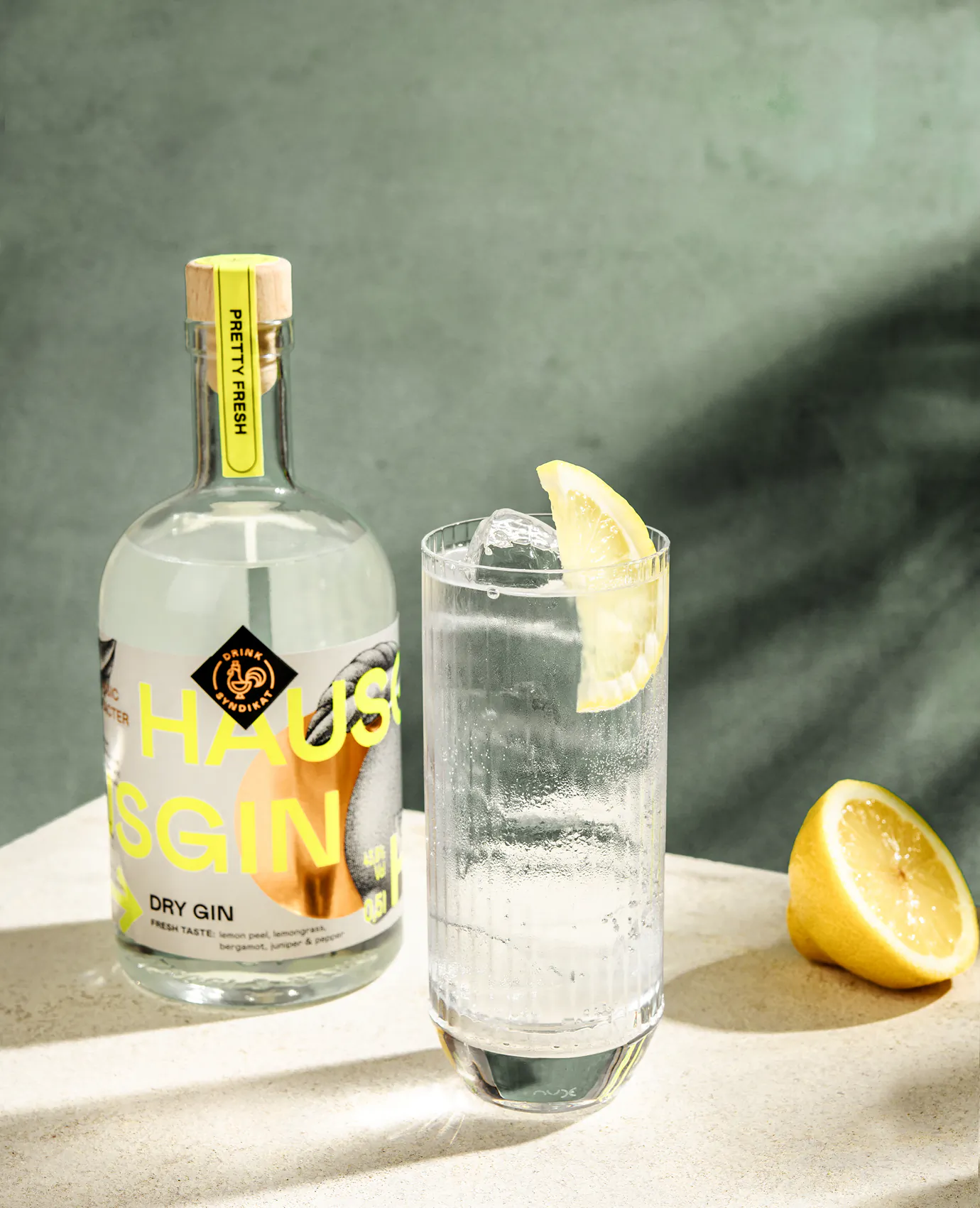 Studioaufnahme der „Haus Gin“-Flasche und eines Longdrinkglases