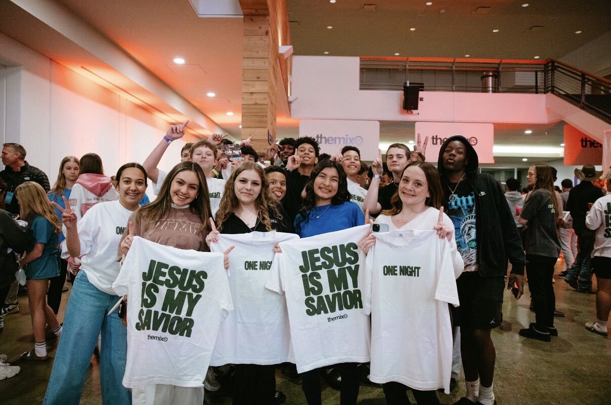 Students holding One Night t-shirts