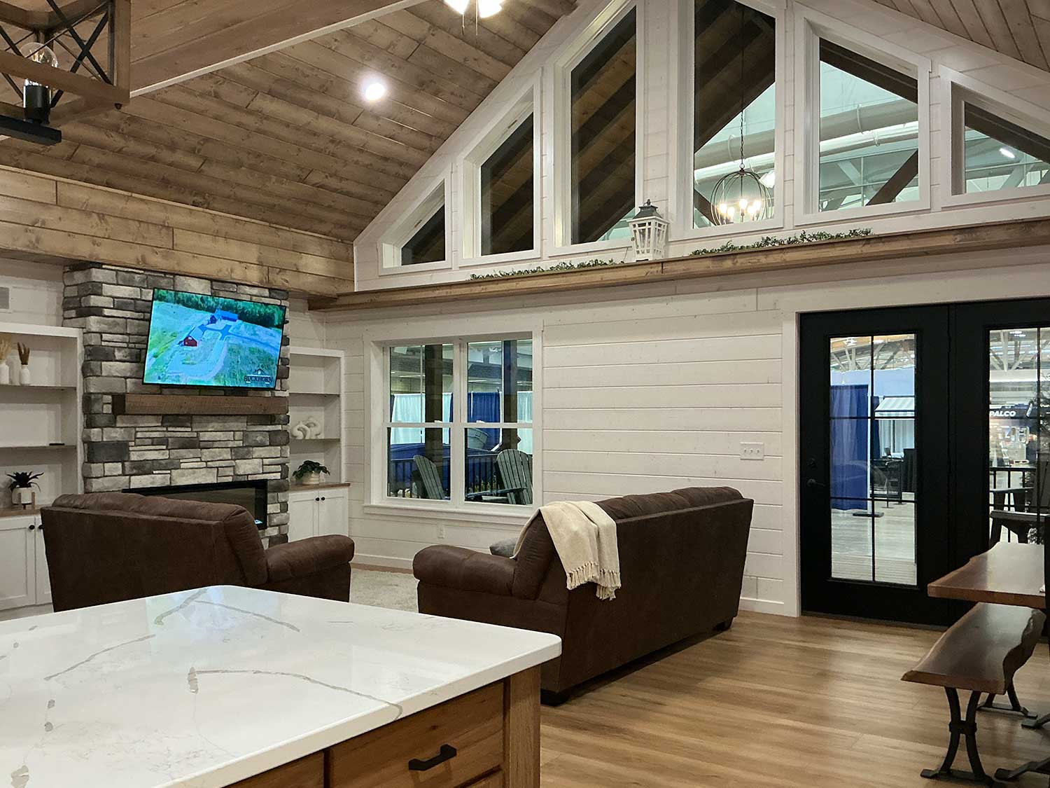 Soaring vaulted ceilings, expansive windows, and a floor-to-ceiling fireplace create a bright, inviting gathering space designed for everyday living and entertaining.