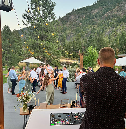 Jordan Waldo DJing while wedding guests fill a Montana dance floor