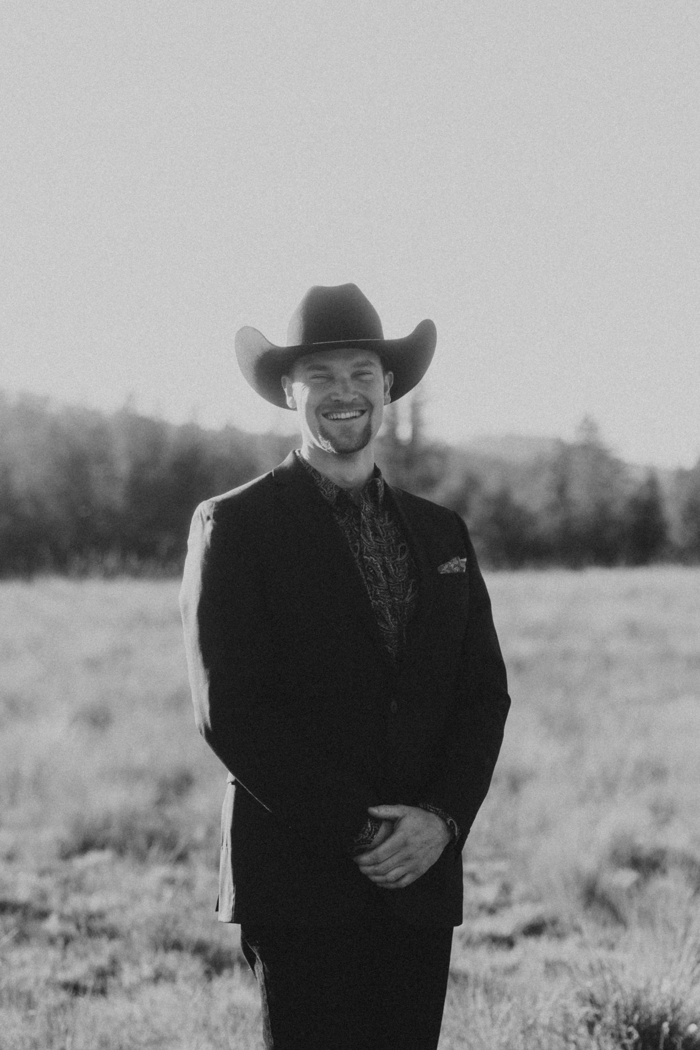 RMF wedding DJ Joshua Backer smiling in a cowboy hat and suit in Montana