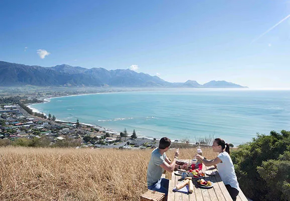 A couple having a picnic with the beach in the background