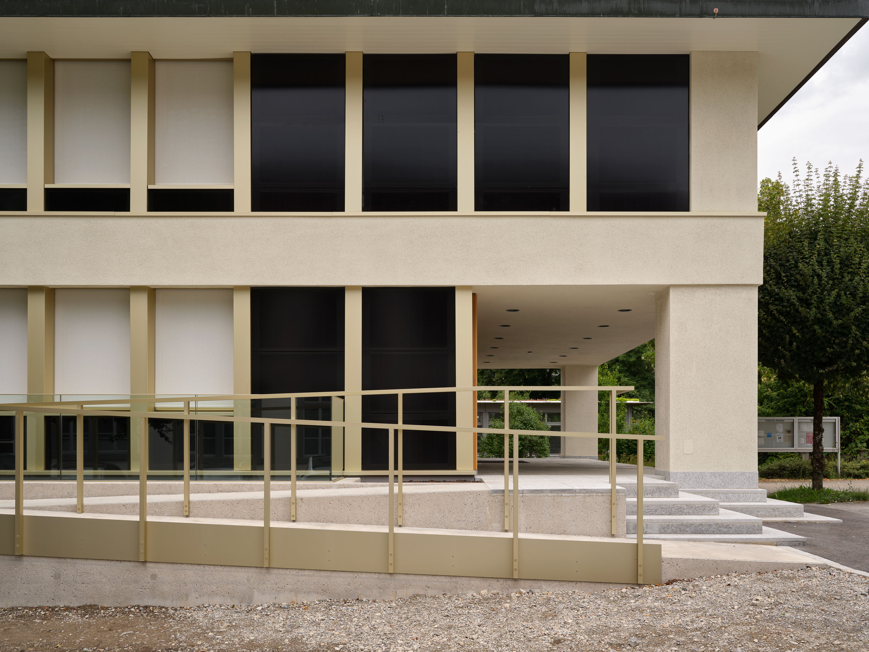 Rampe mit Geländer vor der Fassade und dem überdachten Zugang des Gemeindehauses Turbenthal.