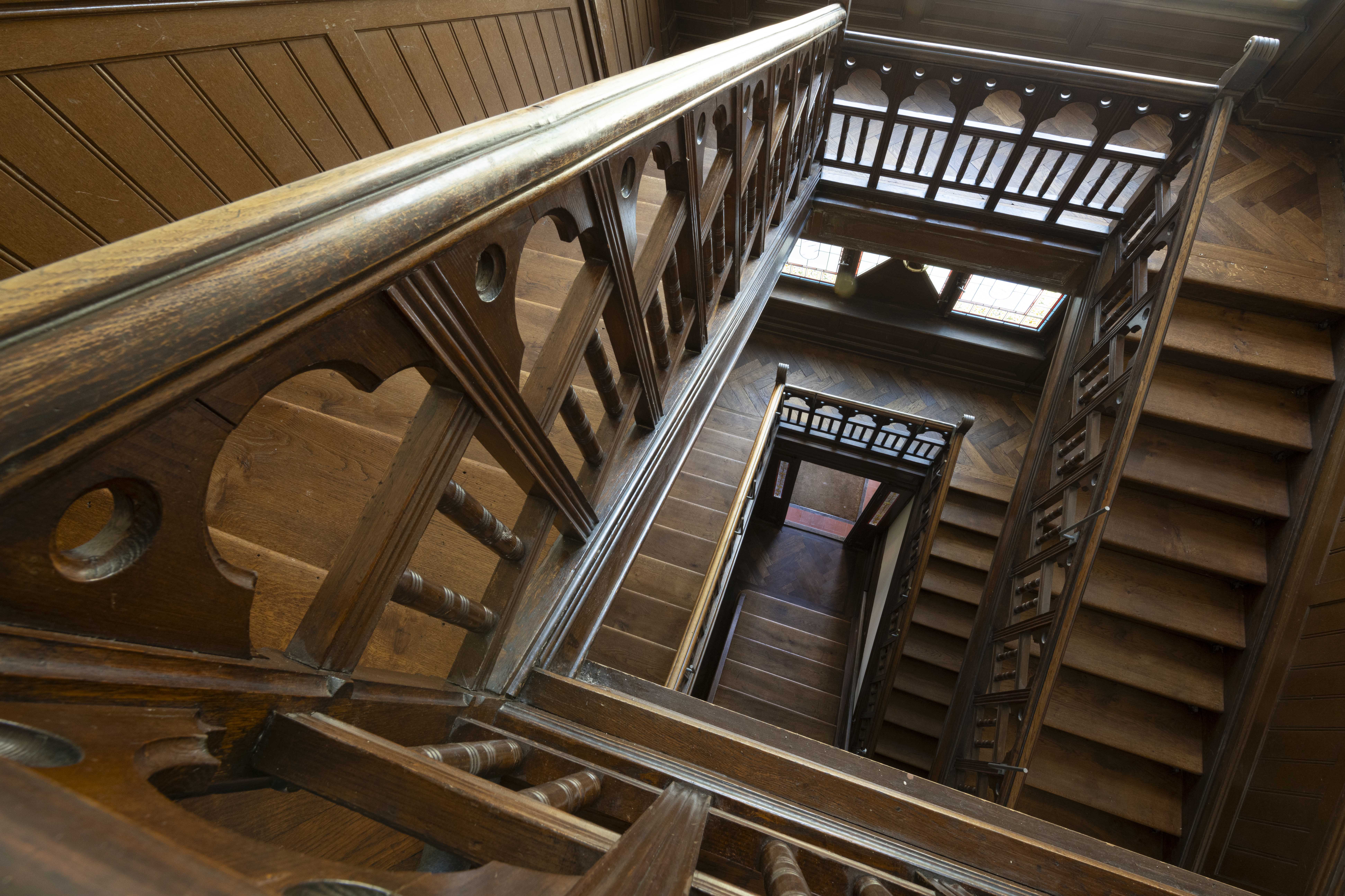 Blick von oben in das historische Holztreppenhaus der Villa Lindeneck.