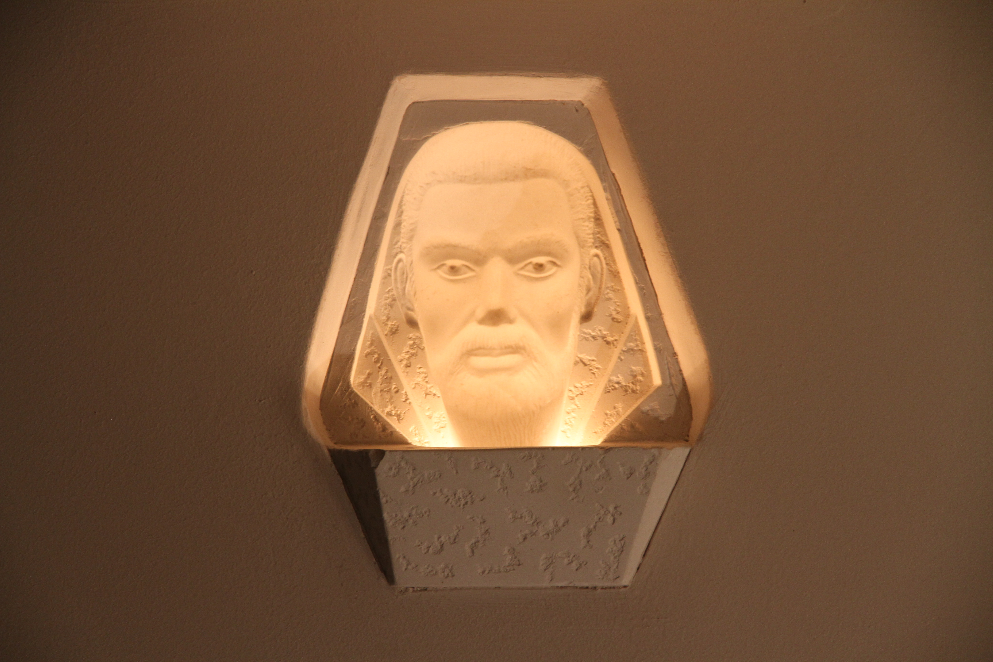 Lichtinstallation «Rasputin» mit beleuchtetem Gesicht in einer Wandnische.