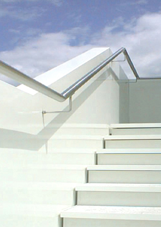 Weisse Treppe mit Glasgeländer und offenem Blick zum Himmel im Penthouse S22.
