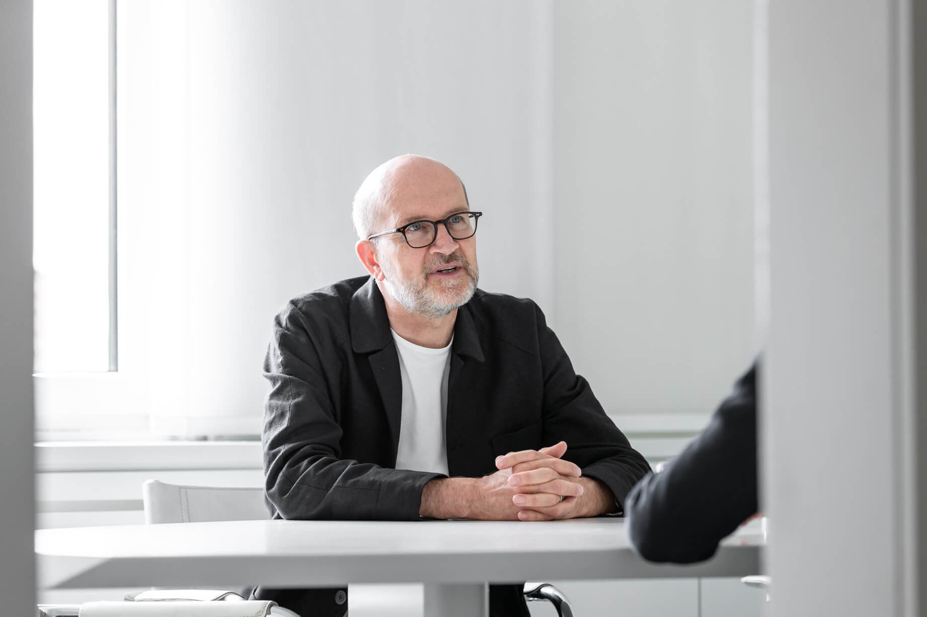Knut Lüscher bei einer Besprechung am Tisch im Architekturbüro.