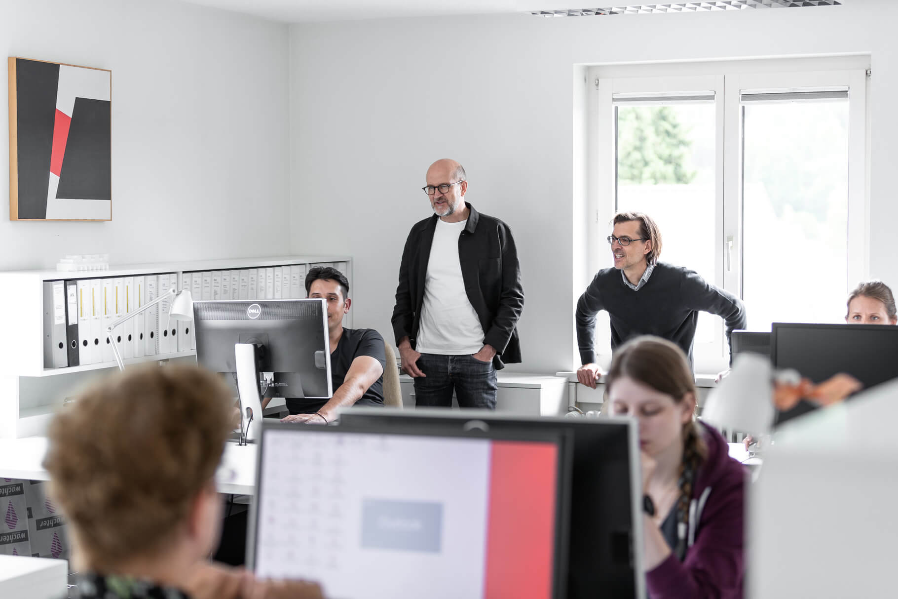 Mitarbeitende an Bildschirmarbeitsplätzen im offenen Büro von Lüscher-Lüscher Architekten.