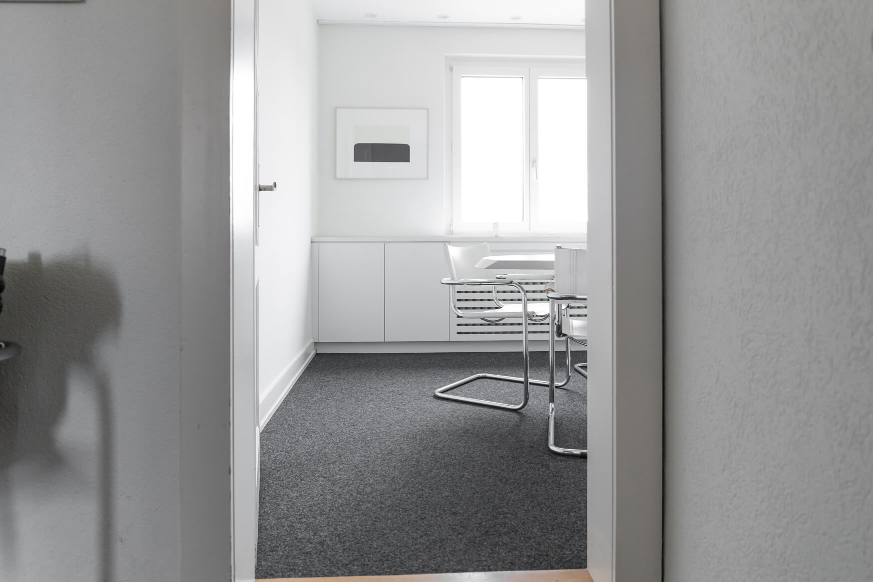 Blick durch die Tür in das helle Sitzungszimmer von Lüscher-Lüscher Architekten.