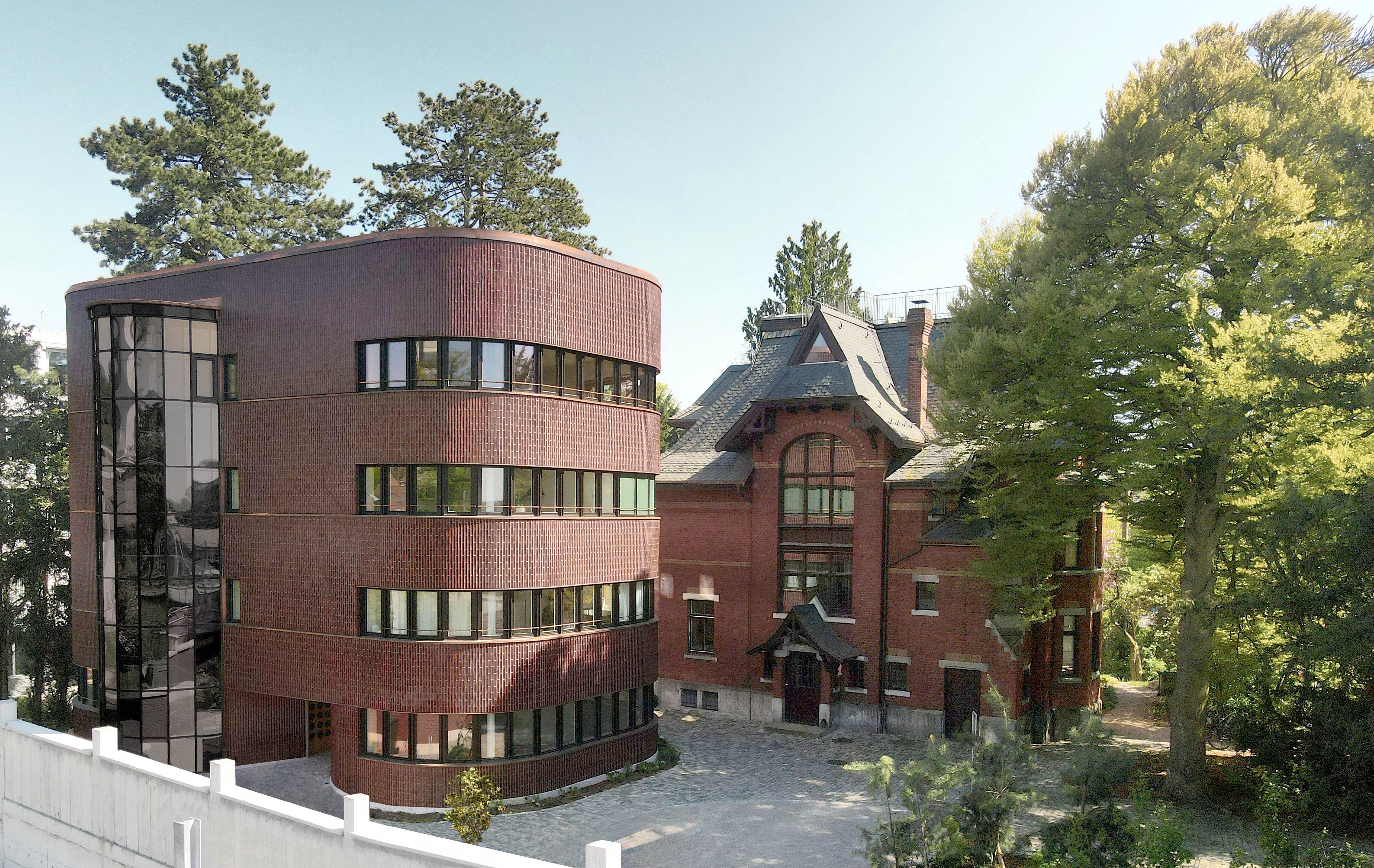 Geburtshaus Winterthur mit historischer Villa Lindeneck und gerundetem Ergänzungsgebäude zwischen Bäumen.
